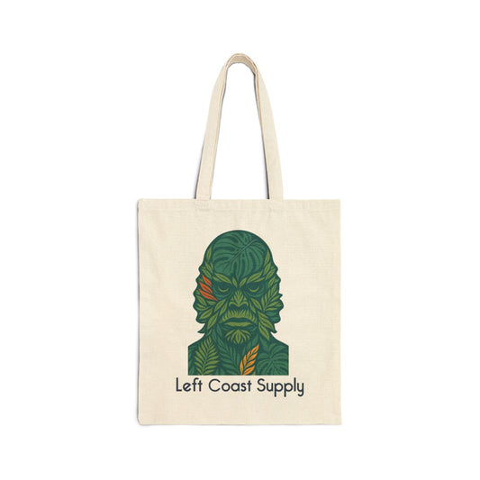 An off-white canvas tote bag with two handles, featuring a stylized green leaf-patterned character graphic and the text 'Left Coast Supply' printed on the front, set against a plain white background.