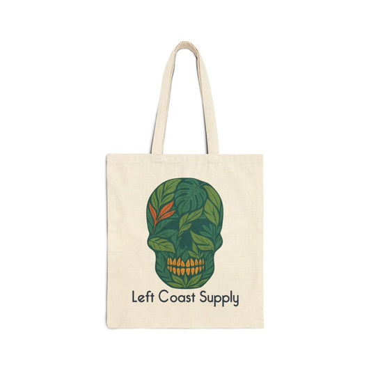 An off-white canvas tote bag with two shoulder straps, featuring a green leaf-patterned skull graphic and the text 'Left Coast Supply' printed below it, set against a plain white background.