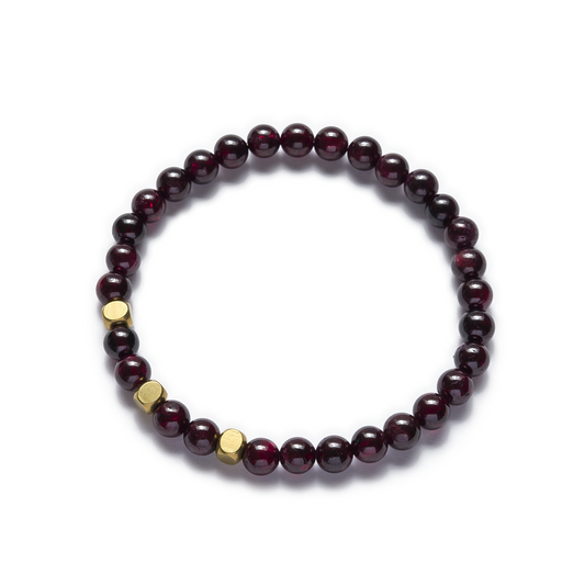 A stretch bracelet made with natural red garnet beads and raw brass accents. Left Coast Supply