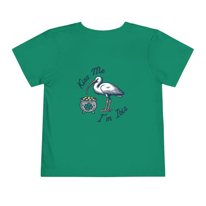 Green toddler T-shirt with the text 'Kiss Me I'm Ibis' and an illustration of an ibis bird and a pot of gold. Left Coast Supply