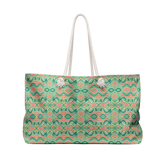 Beach tote with a watercolor pattern featuring mermaids and sunset hues, with white nautical rope handles. Left Coast Supply
