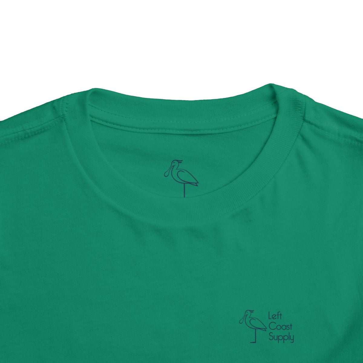 Green toddler T-shirt with the text 'Kiss Me I'm Ibis' and an illustration of an ibis bird and a pot of gold. Left Coast Supply